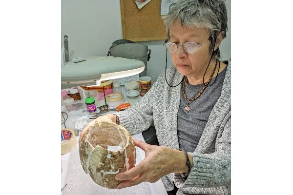 Conservator Olga Negnevitsky during vessel restoration (Photo: Ianir Milevski, Antiquities Authority).
