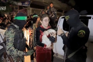 Hamas terrorists seen next to an Israeli hostage being released as part of the Israel-Hamas truce in November 2023.
Photo: Screenshot from footage released by Hamas, via Reuters.