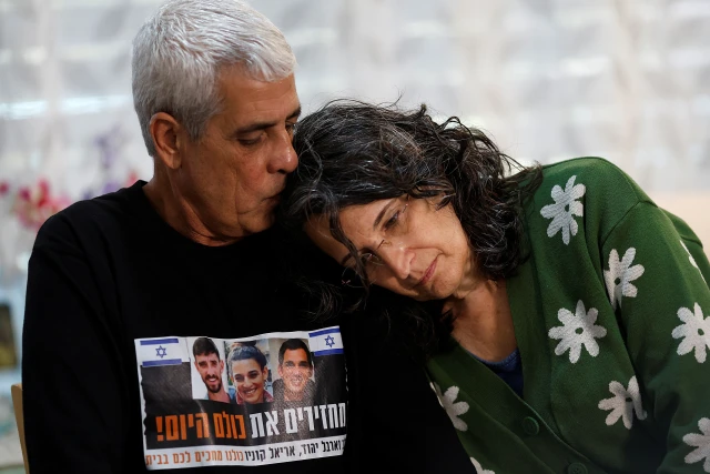 Yechi Yehoud kisses his wife Yael, as they speak to Reuters during an interview in their home in Rishon LeZion, Israel, February 6, 2024. Yehoud's son and daughter, Dolev and Arbel, were kidnapped in the deadly October 7 attack on Israel by the Palestinian Islamist group Hamas. Arbel Yehoud was taken hostage along boyfriend Ariel Cunio, whose brother David Cunio was also kidnapped during the attack. REUTERS/Susana Vera