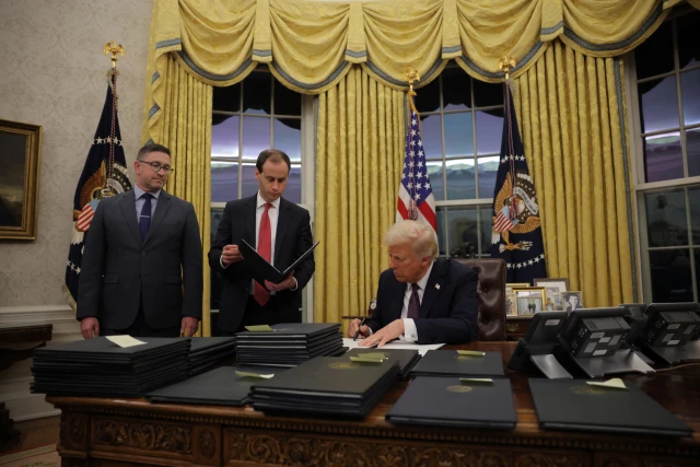U.S. President Donald Trump signs documents as he issues executive orders and pardons for January 6 defendants in the Oval Office at the White House on Inauguration Day in Washington, U.S., January 20, 2025. Photo: REUTERS