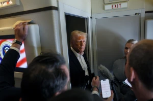 Reporters ask questions to U.S. President Donald Trump aboard Air Force One during a flight from Las Vegas, Nevada, to Miami, Florida, U.S., January 25, 2025. REUTERS/Leah Millis