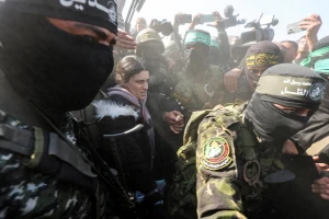 Palestinian militants surround hostage Arbel Yehoud, held in Gaza since the deadly October 7 2023 attack, on the day they hand her over to members of the International Committee of the Red Cross (ICRC) as part of a ceasefire and a hostages-prisoners swap deal between Hamas and Israel, in Khan Younis in the southern Gaza Strip, January 30, 2025. REUTERS/Ramadan Abed