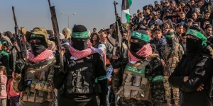 Hamas members and Palestinians watch as Israeli hostages are handed over to Red Cross representatives in the southern Gaza Strip city of Khan Younis.