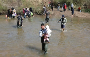 Alawite Syrians, who fled the violence in western Syria, walk in Nahr El Kabir River, after the reported mass killings of Alawite minority members, in Akkar, Lebanon March 11, 2025. REUTERS/Mohamed Azakir