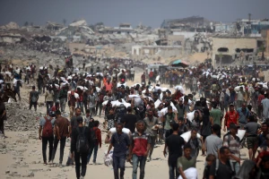 Palestinians walk with sacks of flour delivered after trucks carrying humanitarian aid enter northern Gaza on July 27, 2025, coming from the Zikim border crossing. (Photo by Reuters/Majdi Fathi/NurPhoto)