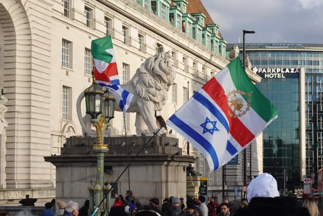 Pre-revolutionary Iranian flags flown alongside Israeli flags by demonstrators in London, England, United Kingdom, on December 24, 2025. The joint display represents a growing solidarity between segments of the Iranian diaspora and the state of Israel following military escalations between Israel and the Islamic Republic in mid-2025. Photo by Michael Nguyen/NurPhoto via Reuters.