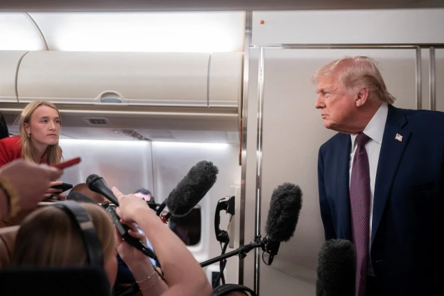 U.S. President Donald Trump speaks with members of the media aboard Air Force One en route from Florida to Joint Base Andrews, Maryland, U.S., January 11, 2026. Photo: Reuters Connect by Nathan Howard