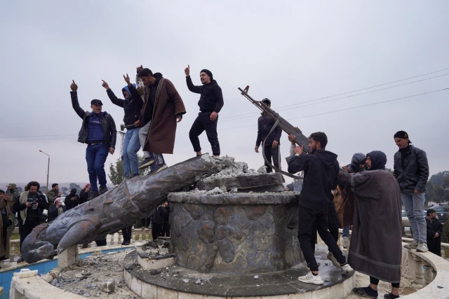 A group of civilians smash a statue of a Syrian Democratic Forces fighter in the city of Tabqa after the Syrian army took control of it, in Tabqa, Syria, January 18, 2026. Photo: Reuters Connect by Karam al-Masri