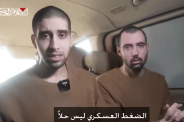 Evyatar David and Guy Gilboa-Dalal watch the broadcast of the release of fellow Israeli hostages in Nuseirat, central Gaza, on February 22, 2025. Photo: Screenshot from a video released by Hamas.