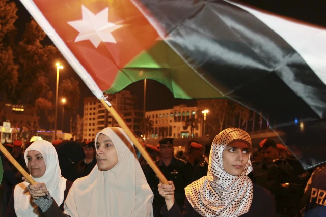 Anti-government protesters hold Jordanian flags as they demonstrate (REUTERS/Muhammad Hamed)