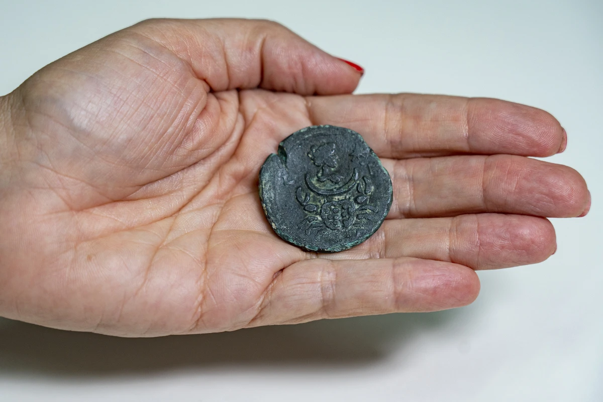 The coin bearing the image of Luna, the goddess of the moon. Below it appears a sign of cancer luck. Photo: Yaniv Berman, Israel Antiquities Authority
