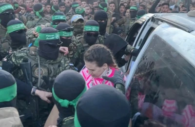Hamas militants hand over Doron Steinbrecher, a hostage who had been held in Gaza since the deadly October 7 2023 attack, to members of the International Committee of the Red Cross (ICRC) as part of a ceasefire and a hostages-prisoners swap deal between Hamas and Israel, in Gaza City, January 19, 2025 (Photo: Screenshot/REUTERS)