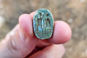 The scarab, showing a seated figure on the right and a standing figure with a raised arm on the left, possibly symbolizing the imparting of authority. Photo: Gilad Stern, Israel Antiquities Authority.