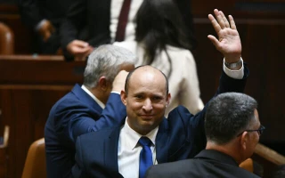 Newly elected Prime Minister Naftali Bennett waves after their new coalition wins Knesset approval, June 13, 2021 (Photo: Haim Zach/GPO)