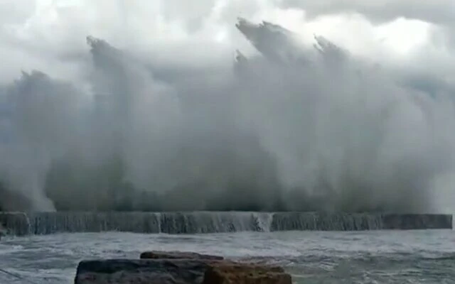 Screen capture from video of waves breaking against the shore in Caesarea, December 20, 2021. (Twitter)