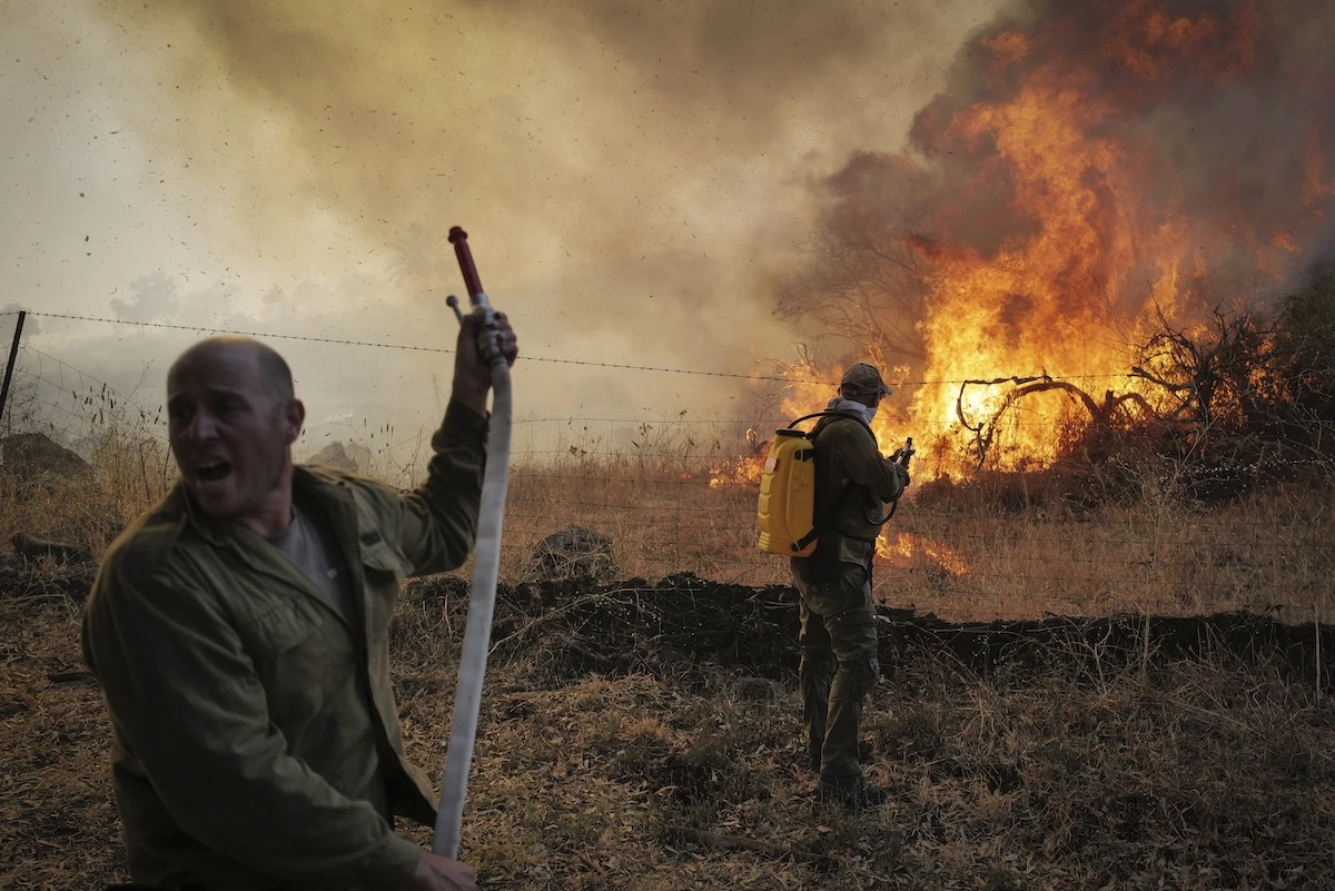 Israeli firefighters and civilians try to extinguish a fire which broke out from missiles and drones fired from Lebanon, at the Ein Kshatot National Heritage Site in Moshav Natur, Moshav Aniam , Golan Heights, July 4, 2024. (Photo by Michael Giladi/ Flash90)