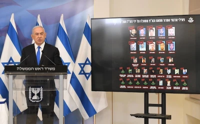 Prime Minister Benjamin Netanyahu gives a statement at a press conference after the Gaza ceasefire, Tel Aviv, May 21, 2021. At his side is a screen showing Gaza terror commanders killed in Operation Guardian of the Walls (Amos Ben Gershom/GPO)