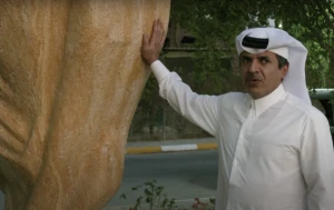 Qatari Sheikh Hamad Al Suwaidi with a three-meter high stone replica of the soccer world cup he installed outside his home in Doha.