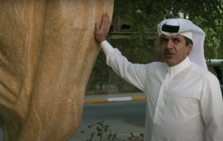 Qatari Sheikh Hamad Al Suwaidi with a three-meter high stone replica of the soccer world cup he installed outside his home in Doha.