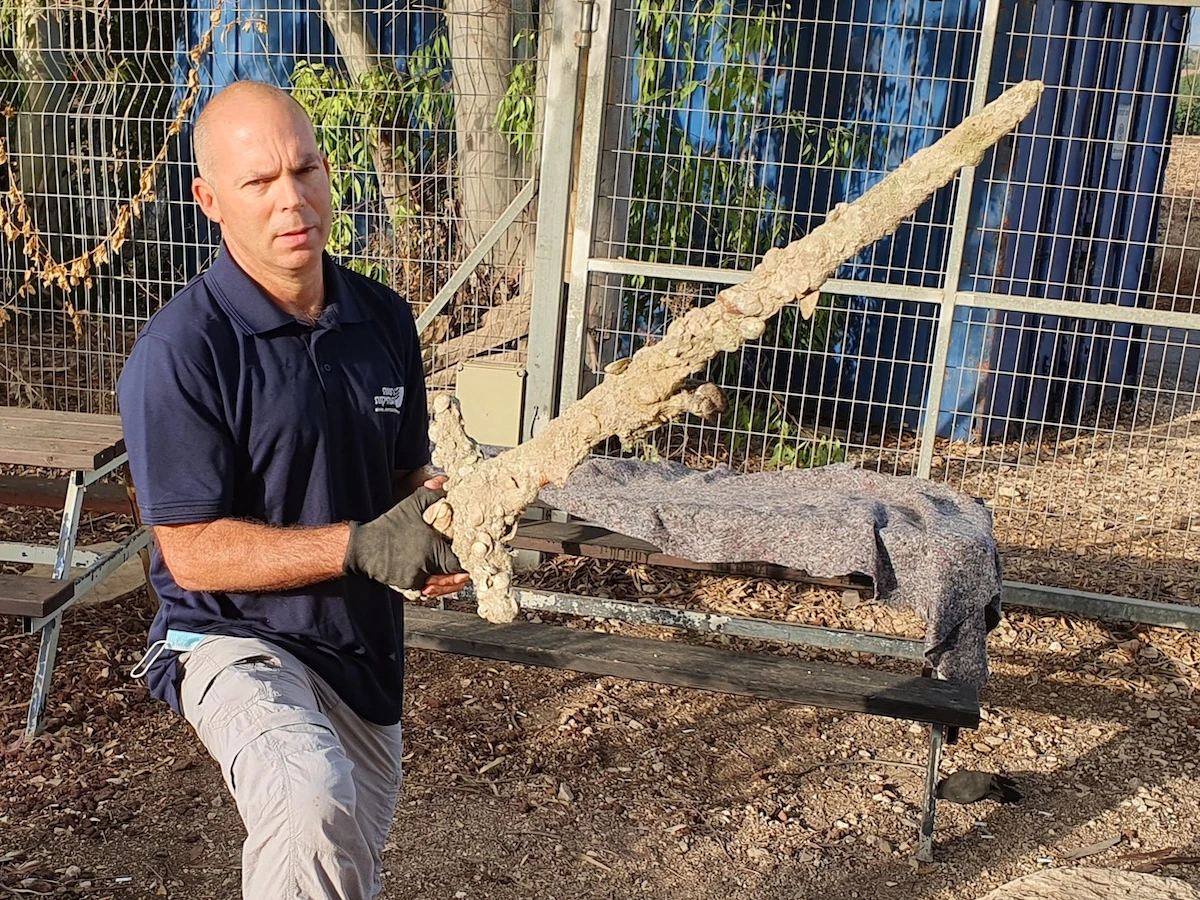 Nir Distelfeld, inspector for the Israel Antiquities Authority, with the Crusader sword. Photo: Anastasia Shapiro, Israel Antiquities Authority