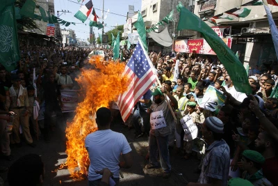 Palestinian men burn the US flag during a protest against a film mocking Islam, in Rafah, southern Gaza Strip, on September 14, 2012. Photo by Abed Rahim Khatib / Flash 90
