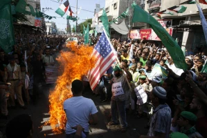 Palestinian men burn the US flag during a protest against a film mocking Islam, in Rafah, southern Gaza Strip, on September 14, 2012. Photo by Abed Rahim Khatib / Flash 90