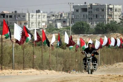 Member of Hamas security forces rides a motorcycle next to Palestinian and Qatar flags during preparations for the celebratory reception of Qatar's Emir Sheik Hamad bin Khalifa al-Thani, in Khan Younis in the southern Gaza Strip on October 22, 2012. The emir of pro-Western Qatar will become the first head of state to enter the blockaded Gaza Strip on Tuesday, in a high-profile visit breaking the isolation of the Iranian-backed Islamist movement Hamas that seized power in 2007. Photo by Abed Rahim Khatib / Flash 90