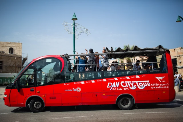 A group of tourists dances to music in their tour bus in Tel Aviv Jaffa, one day after the terror attack at the Jaffa port where one person died and several were injured, March 9, 2016. Photo by Corinna Kern/Flash90