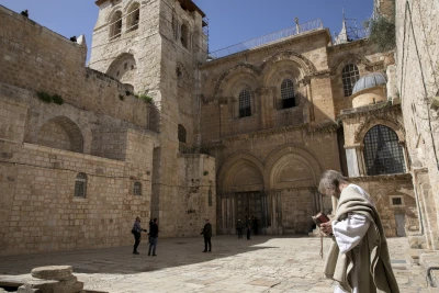 A Christian worshipper prays outside the closed gates of the Holy Sepulchre Church due to the covid-19 virus in the Old city of Jerusalem on April 04, 2020. The government ordered on a partial lockdown, in order to prevent the spread of the Coronavirus. Photo by Olivier Fitoussi/Flash90