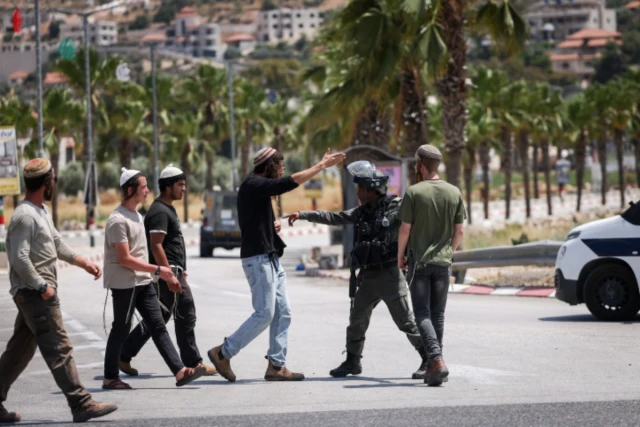 Israeli soldiers and Israeli settlers at the entrance to the West Bank village of Turmus Aya. June 21, 2023 (Photo: Yonatan Sindel/FLASH90).