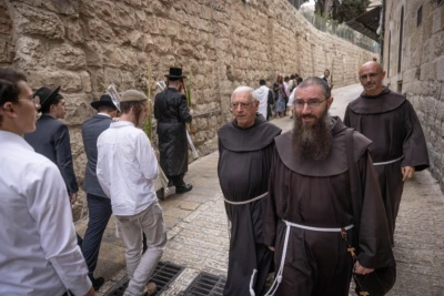 Orthodox Jews walk past Christian clergymen in Jerusalem's Old city, during the Sukkot Holiday, on October 5, 2023 (Photo: Chaim Goldberg/Flash90).