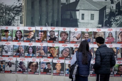 People walk next to pictures of civilians held hostage by Hamas terrorists in Gaza, and some who were released in a deal between Israel and Hamas, in Jerusalem, November 22, 2023 (Photo: Yonatan Sindel/Flash90).