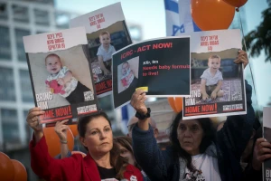 Israelis hold photographs of the Bibas family, and orange balloons, at a press conference calling for the release of 10 month old Kfir, 4 year old Ariel, and their parents Shiri and Yarden Bibas. at "Hostage Square" in Tel Aviv, November 28, 2023. Photo by Miriam Alster/Flash90