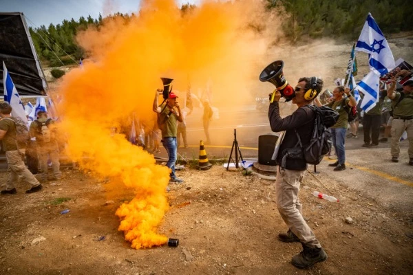 Members of the "Brothers in arms" protest calling for early elections and for the release of hostages held in the Gaza Strip, on road 1, outside of Jerusalem on May 20, 2024 (Photo: Yonatan Sindel/Flash90).