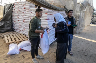 Illustration: Palestinians receive bags of flour at the United Nations Relief and Works Agency for Palestinian Refugees (UNRWA) distribution center, in Hamad City, north of Khan Younis in the southern Gaza Strip, December 3, 2024. Photo by Abed Rahim Khatib/Flash90