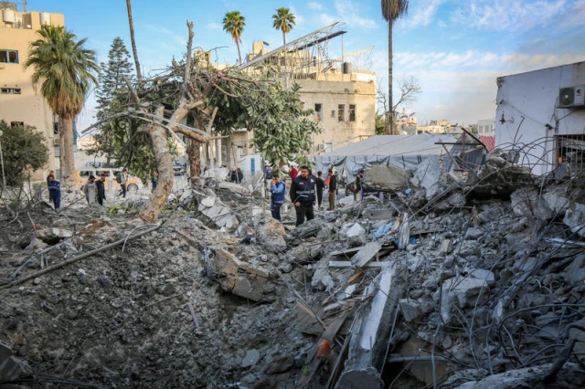 Palestinians inspect the Baptist Hospital building in Gaza City, after it was destroyed in an Israeli airstrike on April 13, 2025. Photo by Ali Hassan/Flash90
