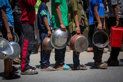 Palestinians receive meals from volunteers in Gaza City, May 21, 2025. Photo by Ali Hassan/Flash90