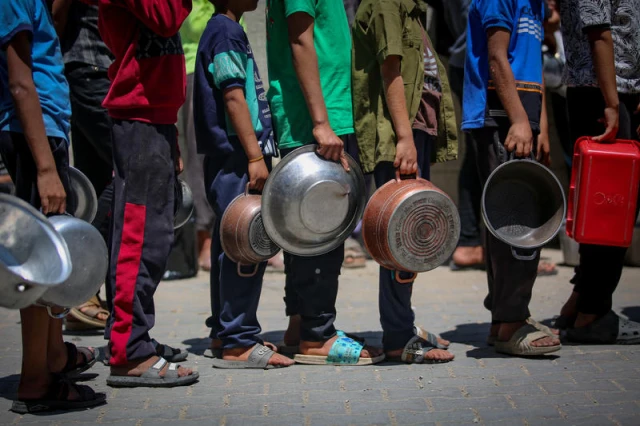Palestinians receive meals from volunteers in Gaza City, May 21, 2025. Photo by Ali Hassan/Flash90