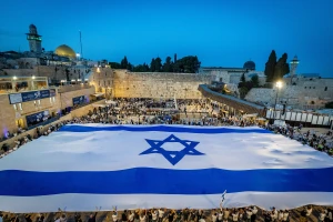 People hold a giant Israeli national flag at the Western Wall in Jerusalem Old City, on the eve of Jerusalem Day, May 25, 2025. Photo by Chaim Goldberg/Flash90