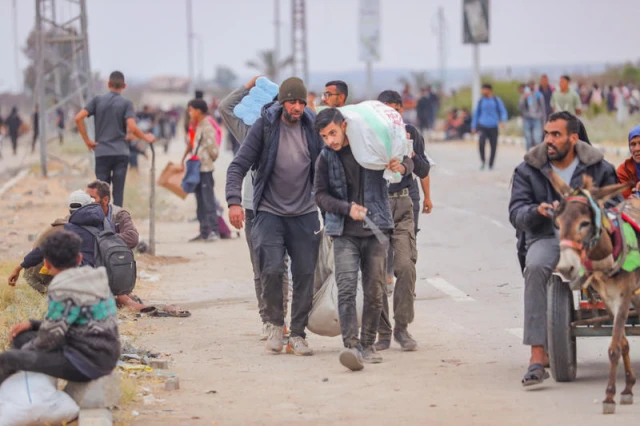 Palestinians walking near aid distribution point in the Netzarim Corridor in the central Gaza Strip on June 9, 2025. Photo by Ali Hassan/Flash90