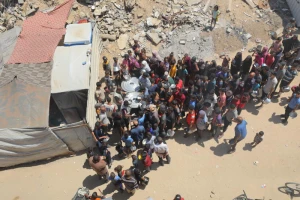 Palestinians receive meals from volunteers in Deir al-Balah, in central Gaza Strip, on July 14, 2025. Photo by Ali Hassan/Flash90