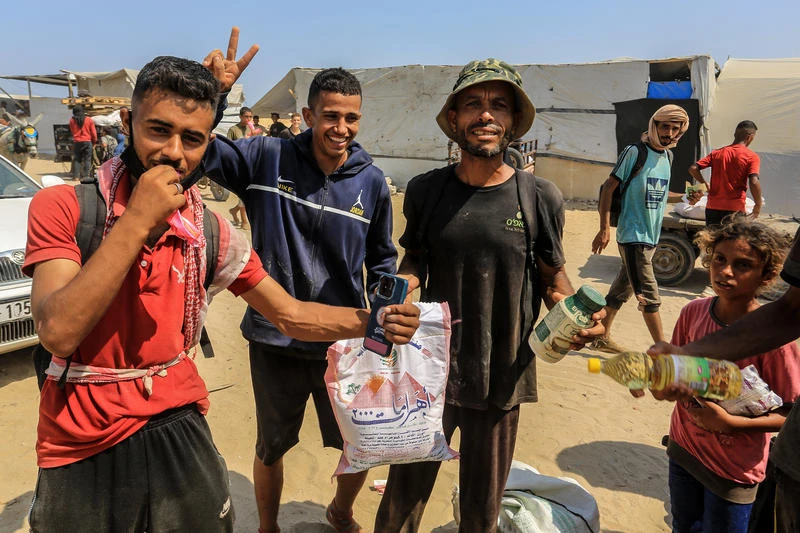 Palestinians carry humanitarian aid in Rafah, in the southern Gaza Strip, August 14, 2025. Photo by Abed Rahim Khatib/Flash90
