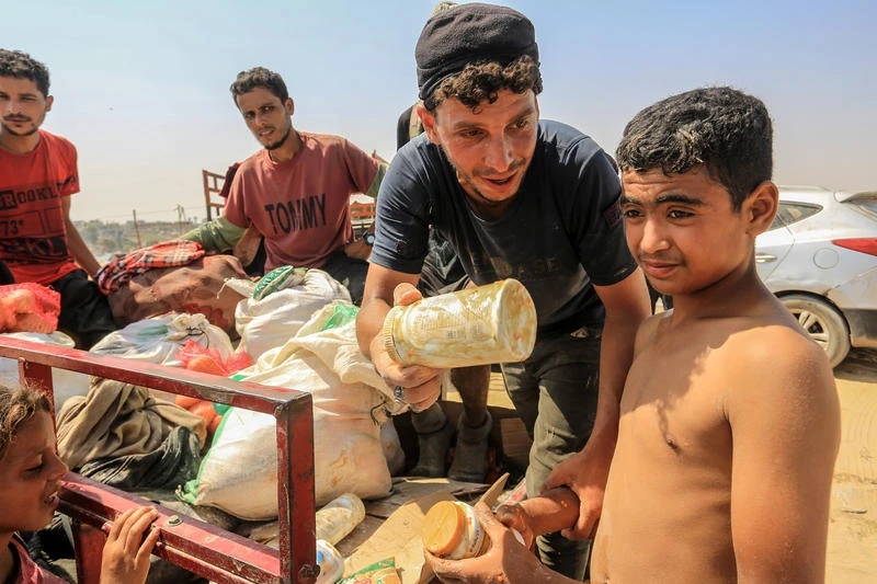 Palestinians carry humanitarian aid in Rafah, in the southern Gaza Strip, August 14, 2025. Photo by Abed Rahim Khatib/Flash90