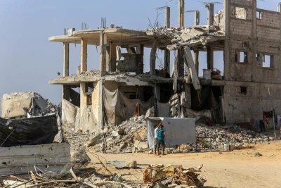Palestinians walk past buildings destroyed in the recent war, in the Jorat al-Luth area, located between Rafah and Khan Younis in the southern Gaza Strip, November 10, 2025. Photo by Abed Rahim Khatib/Flash90