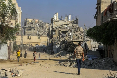 Palestinians walk past buildings destroyed in the recent war, in the Jorat al-Luth area, located between Rafah and Khan Younis in the southern Gaza Strip, November 10, 2025. Photo by Abed Rahim Khatib/Flash90