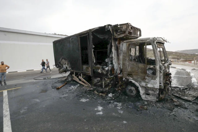 Palestinians inspect burned trucks and cars following an attack by Israeli settlers in the village of Beit Lid, east of Tulkarm, in the West Bank, on November 11, 2025. Photo by Nasser Ishtayeh/Flash90