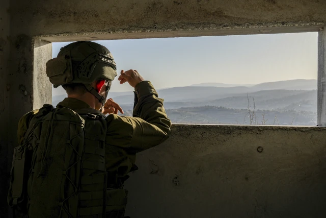 An Israeli soldier looks on as smoke rises in southern Lebanon following an Israeli airstrike, seen from the Israeli side of the border, November 22, 2025. Photo by Ayal Margolin/Flash90