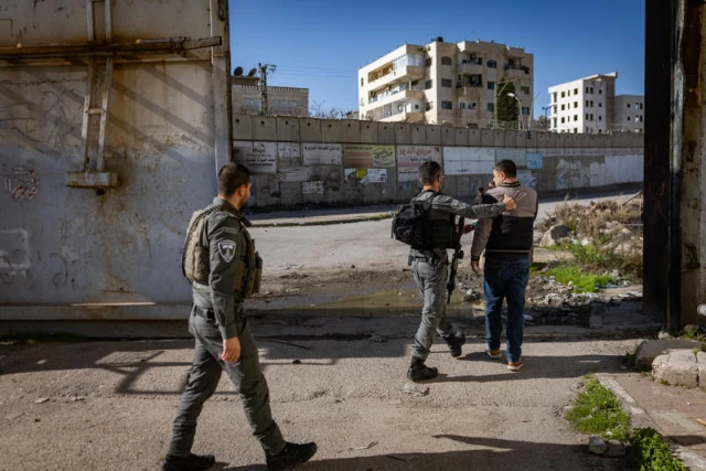 Israeli Border Police officers detain Palestinians who jumped over the separation barrier in the East Jerusalem neighborhood of Beit Hanina, December 23, 2025. Photo by Chaim Goldberg/Flash90