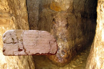 Hezekiah’s Tunnel and the Siloam Inscription, which was discovered inside it. Composite image from Wikimedia Commons.