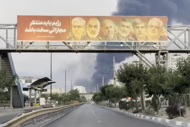 Illustration: Billboard in Iran featuring assassinated IRGC commanders and a message threatening retaliation against Israel, as thick smoke rises in the background following Israeli air strikes. (Screenshot)